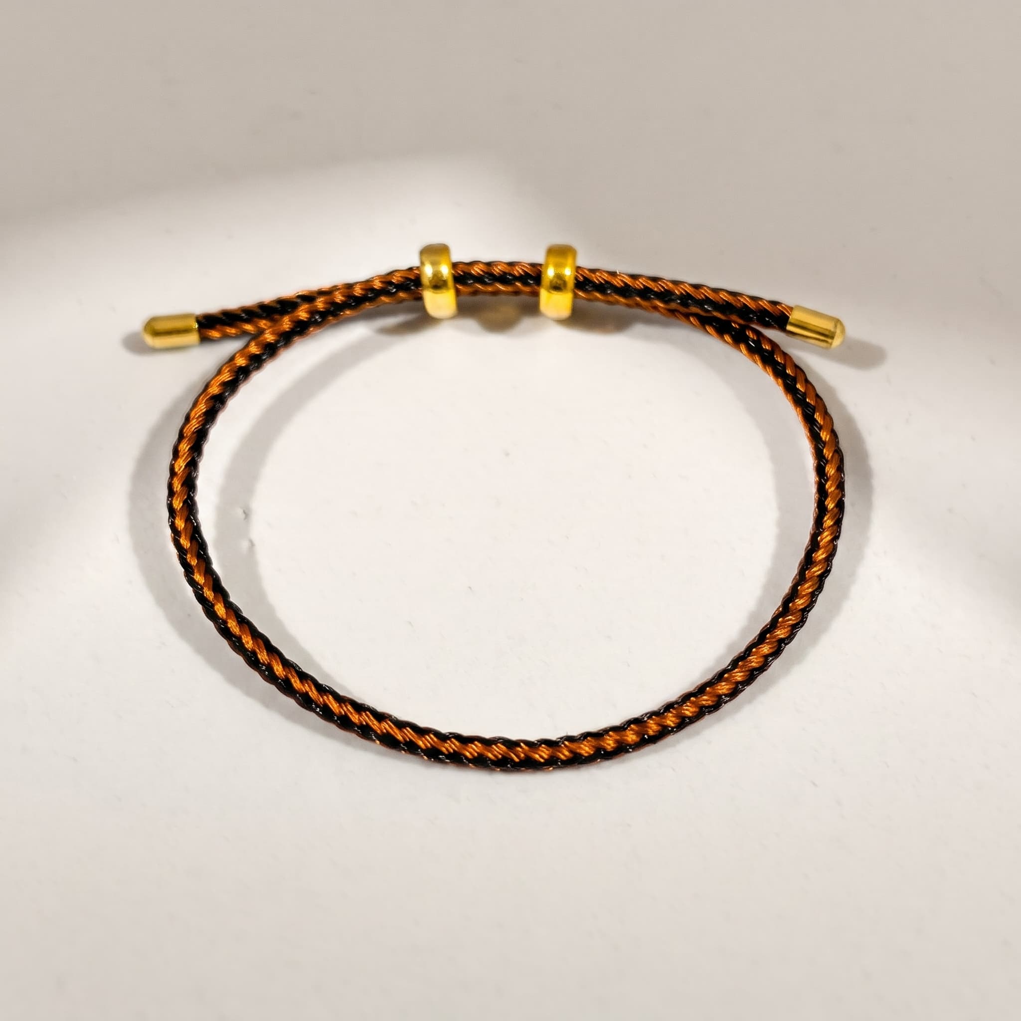 copper and black cord bracelet